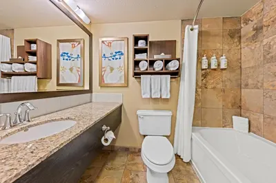 a bathroom with a tub and a toilet and a sink at Wingate by Wyndham Calgary South in Calgary