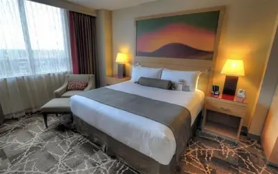 a hotel room with a large bed and a chair at River Rock Casino Hotel in Richmond