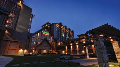 a large building with lights on it at night at River Rock Casino Hotel in Richmond
