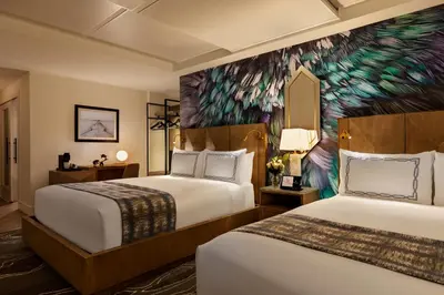 two beds in a hotel room with a peacock mural at EXchange Hotel Vancouver in Vancouver