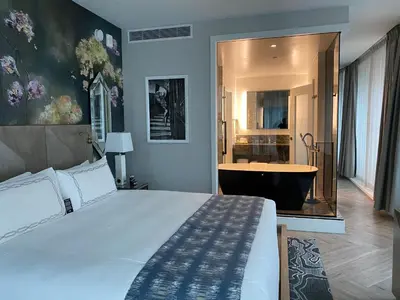 a bedroom with a large bed and a bath tub at EXchange Hotel Vancouver in Vancouver