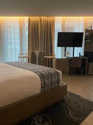 a bedroom with a bed and a desk and a television at EXchange Hotel Vancouver in Vancouver