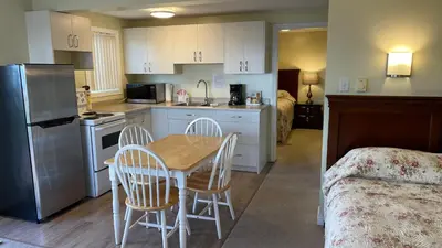 a kitchen with a table and chairs in a room at Buena Vista by the Sea in Qualicum Beach