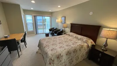 a hotel room with a bed and a desk and a desk at Buena Vista by the Sea in Qualicum Beach