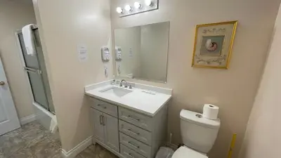 a bathroom with a sink and a toilet and a mirror at Buena Vista by the Sea in Qualicum Beach