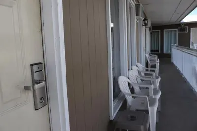 a row of white chairs sitting on a hallway at Plaza Motel in Penticton
