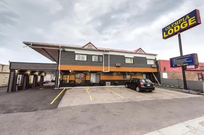 a building with a car parked in a parking lot at Olympia Lodge in Calgary