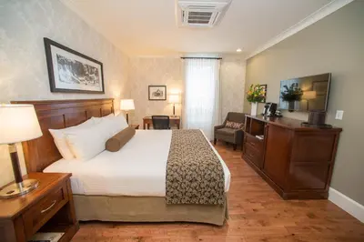 a hotel room with a bed and a chair at Hume Hotel & Spa in Nelson