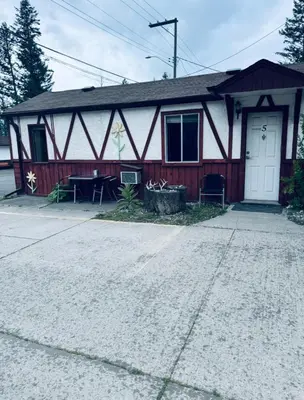 a house with a white door and a porch at Sunset Motel in Radium Hot Springs