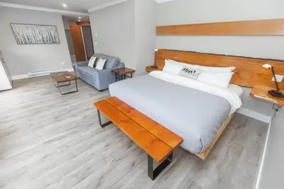 a bedroom with a large bed with a wooden headboard at West Coast Wilderness Lodge in Egmont