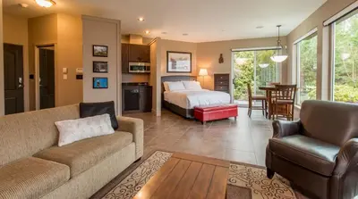a living room with a couch and a bed at Inn the Estuary in Nanoose Bay