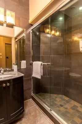 a bathroom with a glass shower and a sink at Inn the Estuary in Nanoose Bay