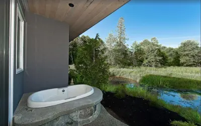 a bath tub in a bathroom with a view of a river at Inn the Estuary in Nanoose Bay