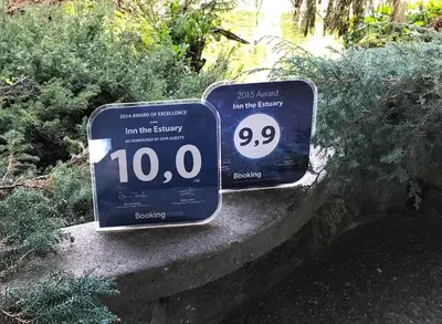 two signs sitting on top of a stone wall at Inn the Estuary in Nanoose Bay