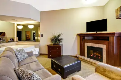 a living room with a couch and a fireplace at Canalta Camrose in Camrose