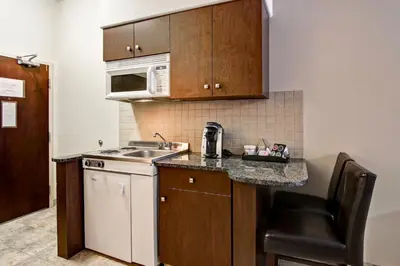 a small kitchen with a sink and a microwave at Canalta Camrose in Camrose