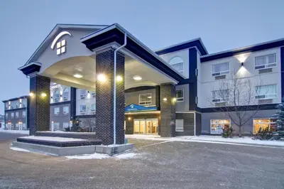 a large building with a parking lot in front of it at Canalta Camrose in Camrose