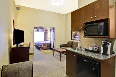 a hotel room with a kitchen and a living room at Canalta Camrose in Camrose