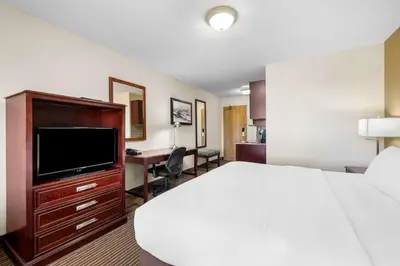a hotel room with a bed and a flat screen tv at SureStay Plus Hotel by Best Western Drumheller in Drumheller