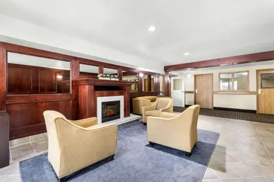 a living room with chairs and a fireplace at SureStay Plus Hotel by Best Western Drumheller in Drumheller