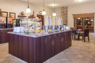 a bar in a restaurant with a counter at Ramada by Wyndham Camrose in Camrose