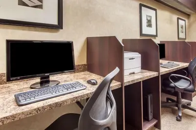 an office with a desk with a computer and a chair at Ramada by Wyndham Camrose in Camrose