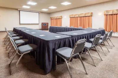 a conference room with a long table and chairs at Ramada by Wyndham Camrose in Camrose