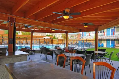 an outdoor patio with tables and chairs and a ceiling fan at Bowmont Motel in Penticton