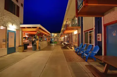 an empty alley with blue chairs on a building at Bowmont Motel in Penticton