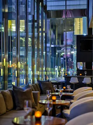 a restaurant with couches and tables and a large window at Hotel Le Germain Calgary in Calgary