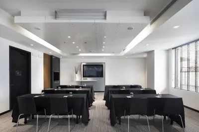 a conference room with black tables and a flat screen tv at Hotel Le Germain Calgary in Calgary