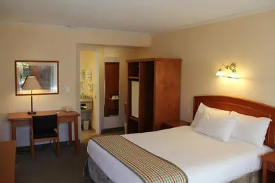 a hotel room with a large bed and a desk at Travelodge by Wyndham Kamloops in Kamloops