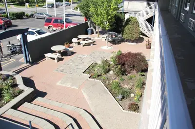 an outdoor patio with tables and benches on a building at Travelodge by Wyndham Kamloops in Kamloops