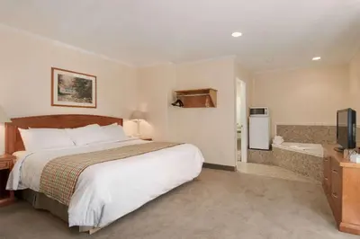 a hotel room with a bed and a bathroom at Travelodge by Wyndham Kamloops in Kamloops