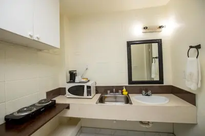 a small kitchen with a sink and a microwave at Camrose Motel in Camrose