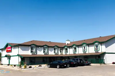 a large white building with cars parked in front of it at Econo Lodge in Okotoks