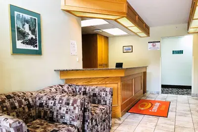 a waiting room with two couches and a bar at Econo Lodge in Okotoks