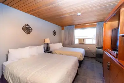 a hotel room with two beds and a television at Vegreville Garden Inn in Vegreville