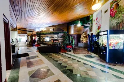a lobby of a restaurant with a christmas tree in the center at Vegreville Garden Inn in Vegreville