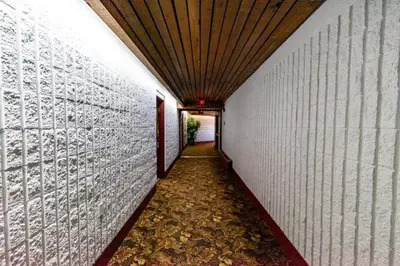 a long hallway with a white wall and a ceiling at Vegreville Garden Inn in Vegreville