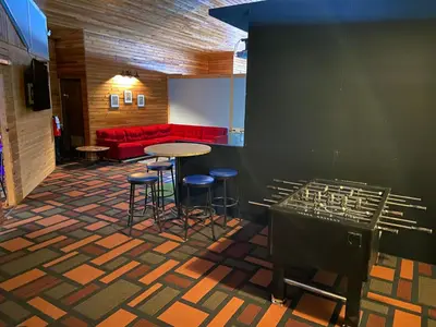 a room with a table and stools and a red couch at Vegreville Garden Inn in Vegreville