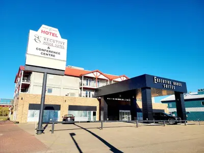 a sign in front of a building with a hotel at Executive House Suites Hotel & Conference Centre in High Level