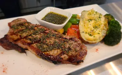 a plate of food with meat and potatoes and vegetables at Executive House Suites Hotel & Conference Centre in High Level