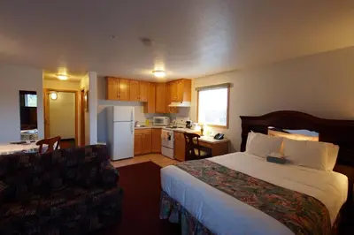 a hotel room with a bed and a kitchen at Executive House Suites Hotel & Conference Centre in High Level