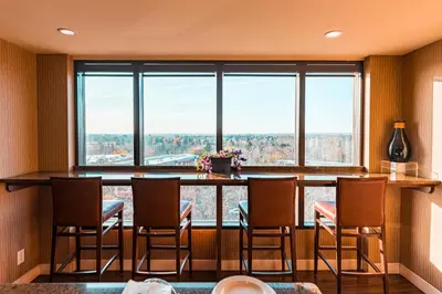 a room with a bar with chairs and a large window at Red Deer Resort & Casino in Red Deer