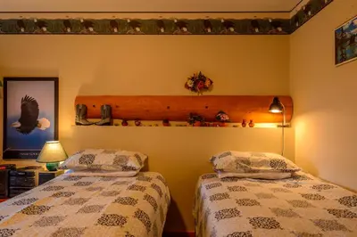 a bedroom with two beds and a shelf on the wall at PineWood Guesthouse in Peachland