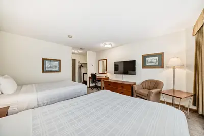 a hotel room with two beds and a desk at Jasper Inn & Suites by INNhotels in Jasper