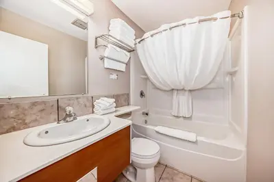 a bathroom with a sink and a tub and a toilet at Jasper Inn & Suites by INNhotels in Jasper
