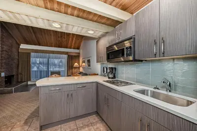 a kitchen with wooden cabinets and a sink at Jasper Inn & Suites by INNhotels in Jasper