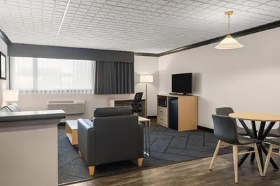 a living room with a table and chairs and a desk at Sternwheeler Hotel & Conference Centre, Trademark by Wyndham in Whitehorse